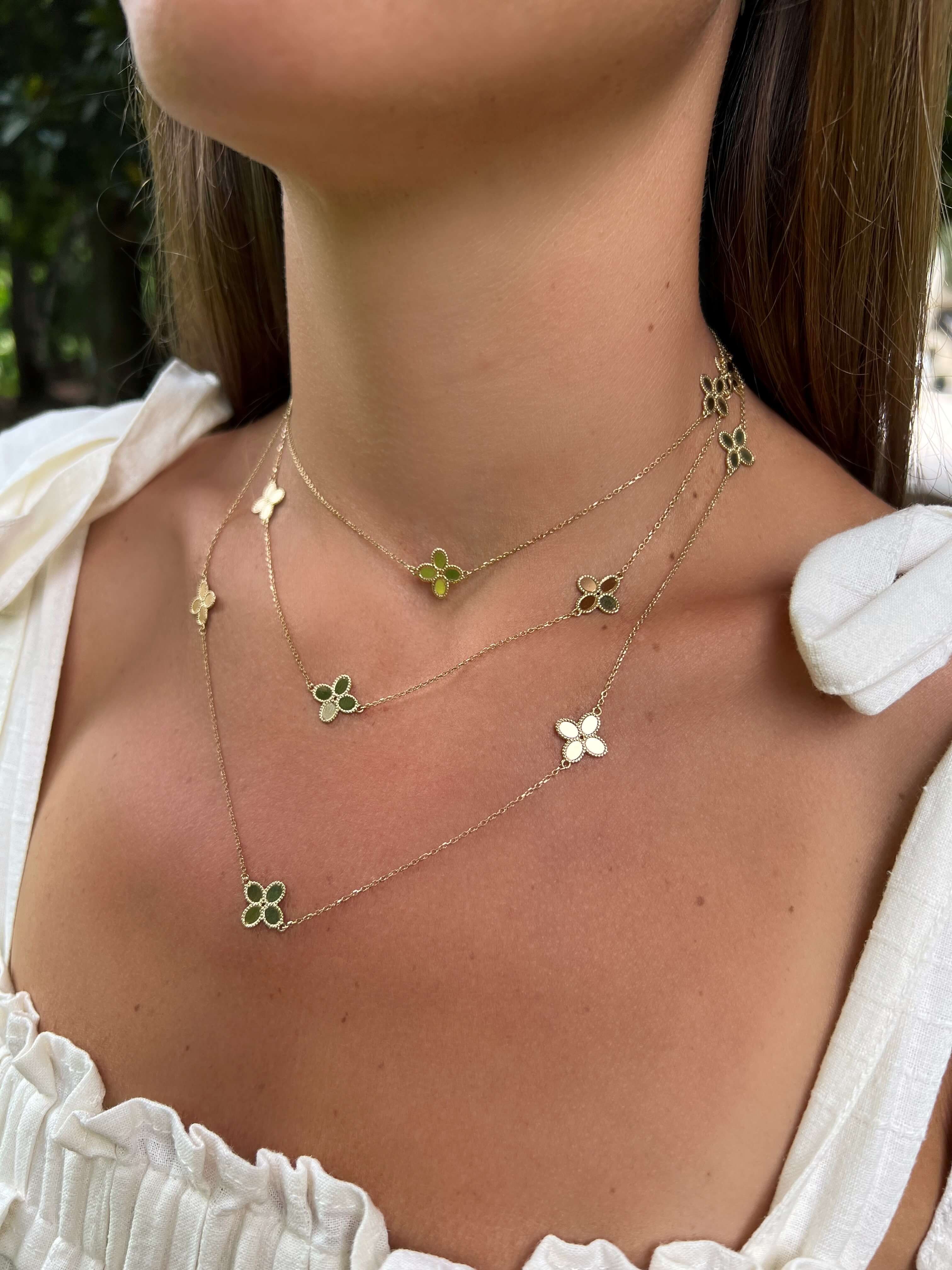 Woman wearing three 14K Yellow Gold Clover Station Necklaces