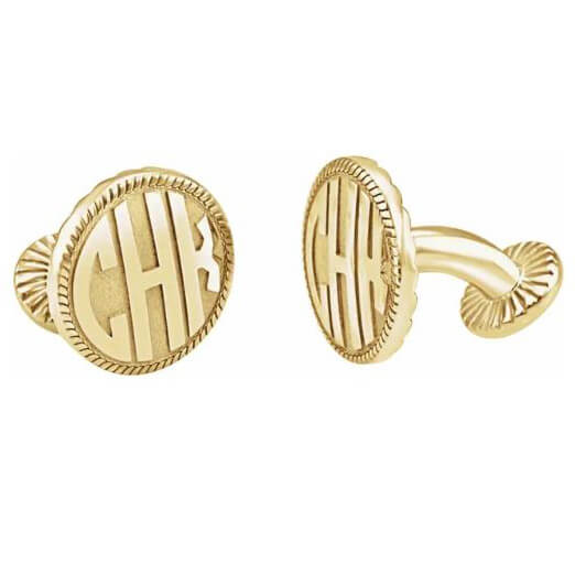 A pair of gold-colored cufflinks with intricate details and monogrammed initials.