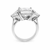 A three-stone diamond ring featuring a large rectangular center diamond and two smaller trillion-cut side diamonds in a polished platinum setting, shown against a plain white background.