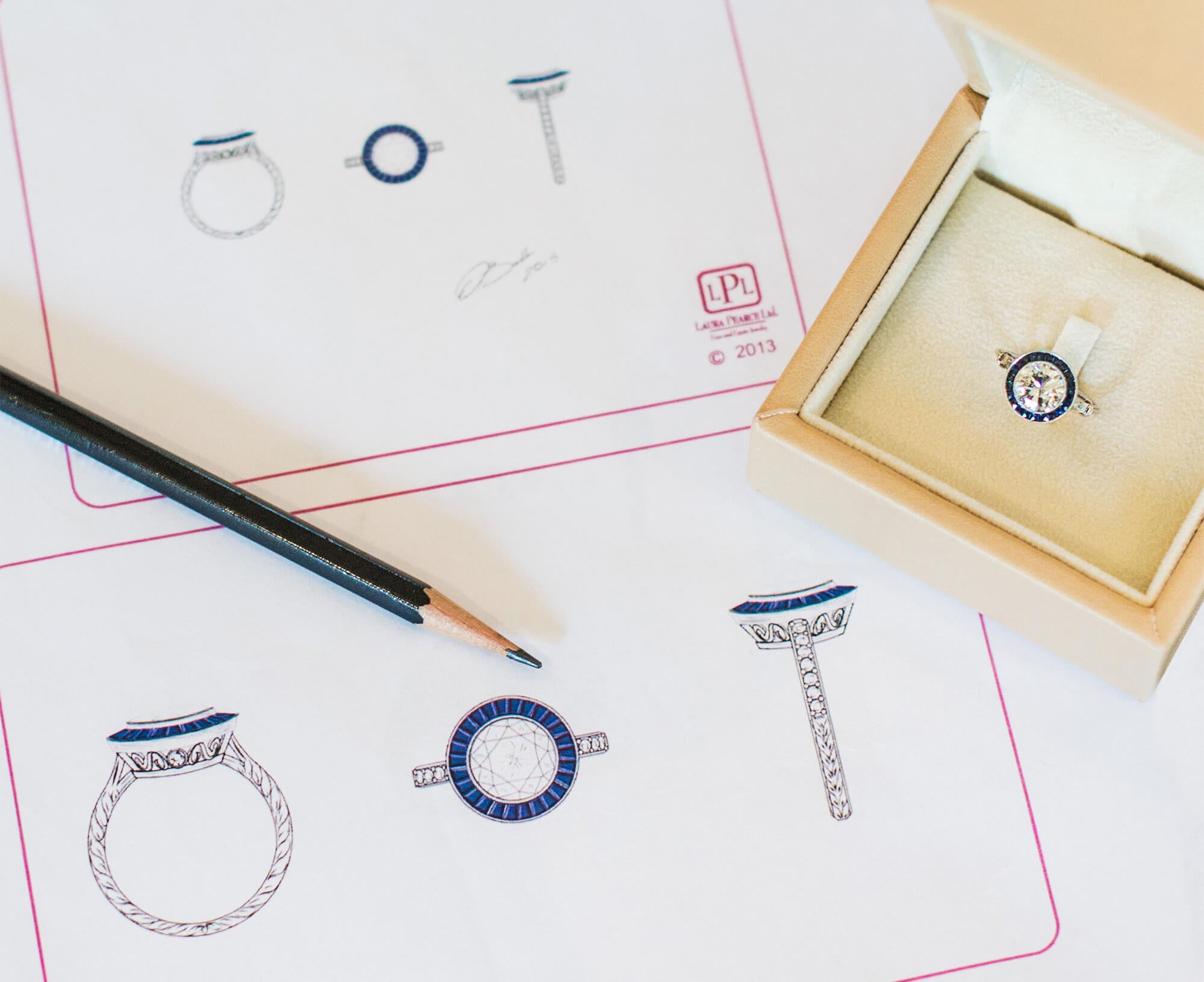 Custom ring design sketches and a box containing a custom ring.