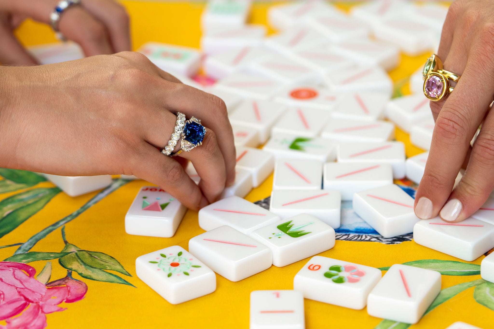 Women wearing fine jewelry playing mahjong.