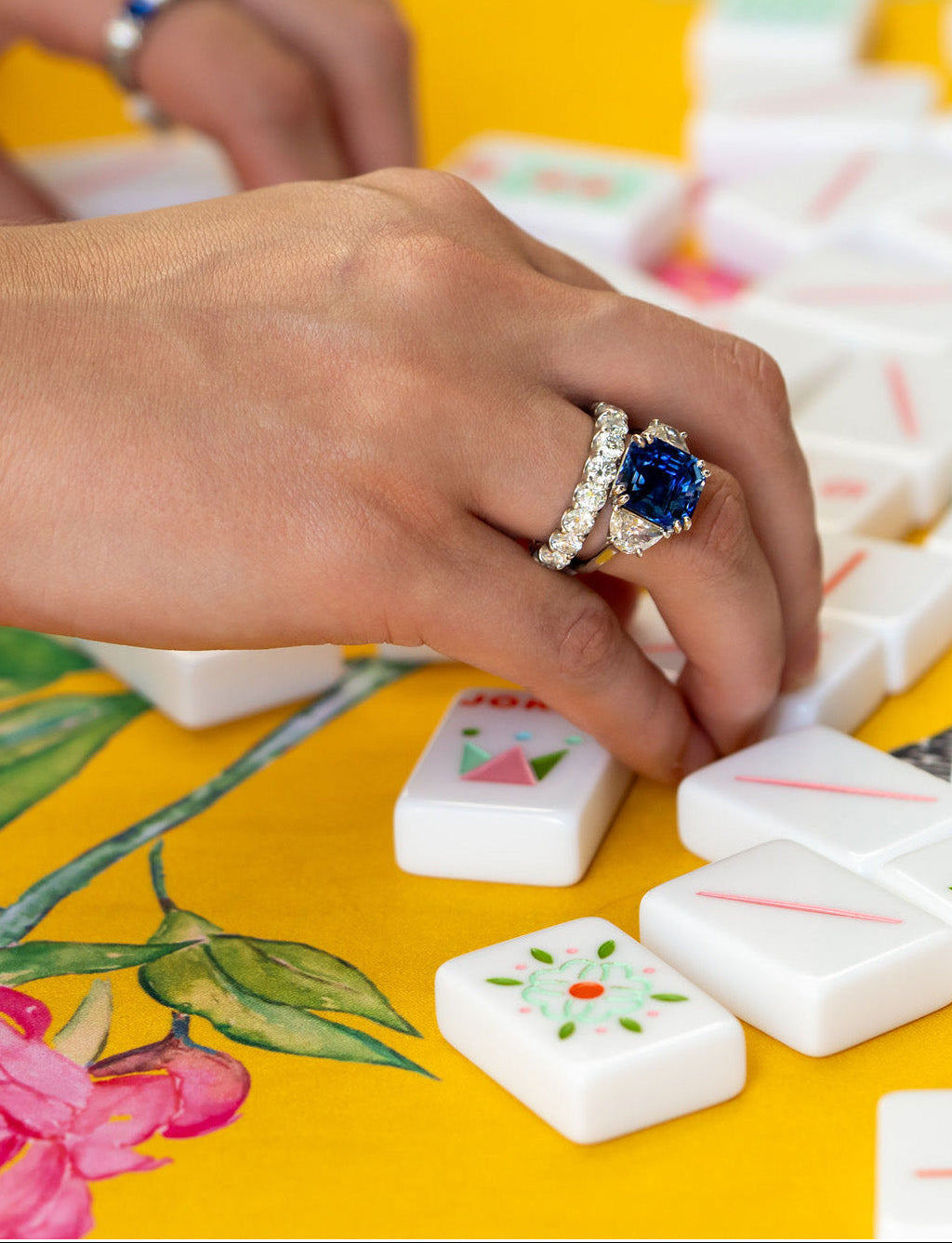 woman wearing a sapphire and diamond ring designed by Laura Pearce