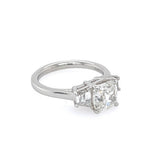 A ring featuring a large cushion-cut diamond center stone with two smaller trapezoid diamonds on either side, set in a polished platinum band against a plain white background.