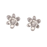A pair of 18K white gold flower stud earrings with a textured petal design and a clear round diamond center, shown on a plain white background.