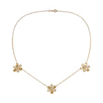 A delicate 18K yellow gold chain necklace featuring three small flower charms, each adorned with clear pavé diamonds, arranged symmetrically on a plain white background.