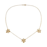 A delicate 18K yellow gold chain necklace featuring three small flower charms, each adorned with clear pavé diamonds, arranged symmetrically on a plain white background.