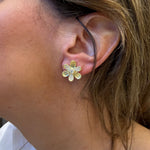 Close-up of a woman wearing a 18K gold flower-shaped earring
