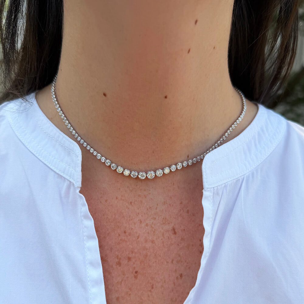 A close-up of a model wearing a delicate 18K white gold diamond tennis 