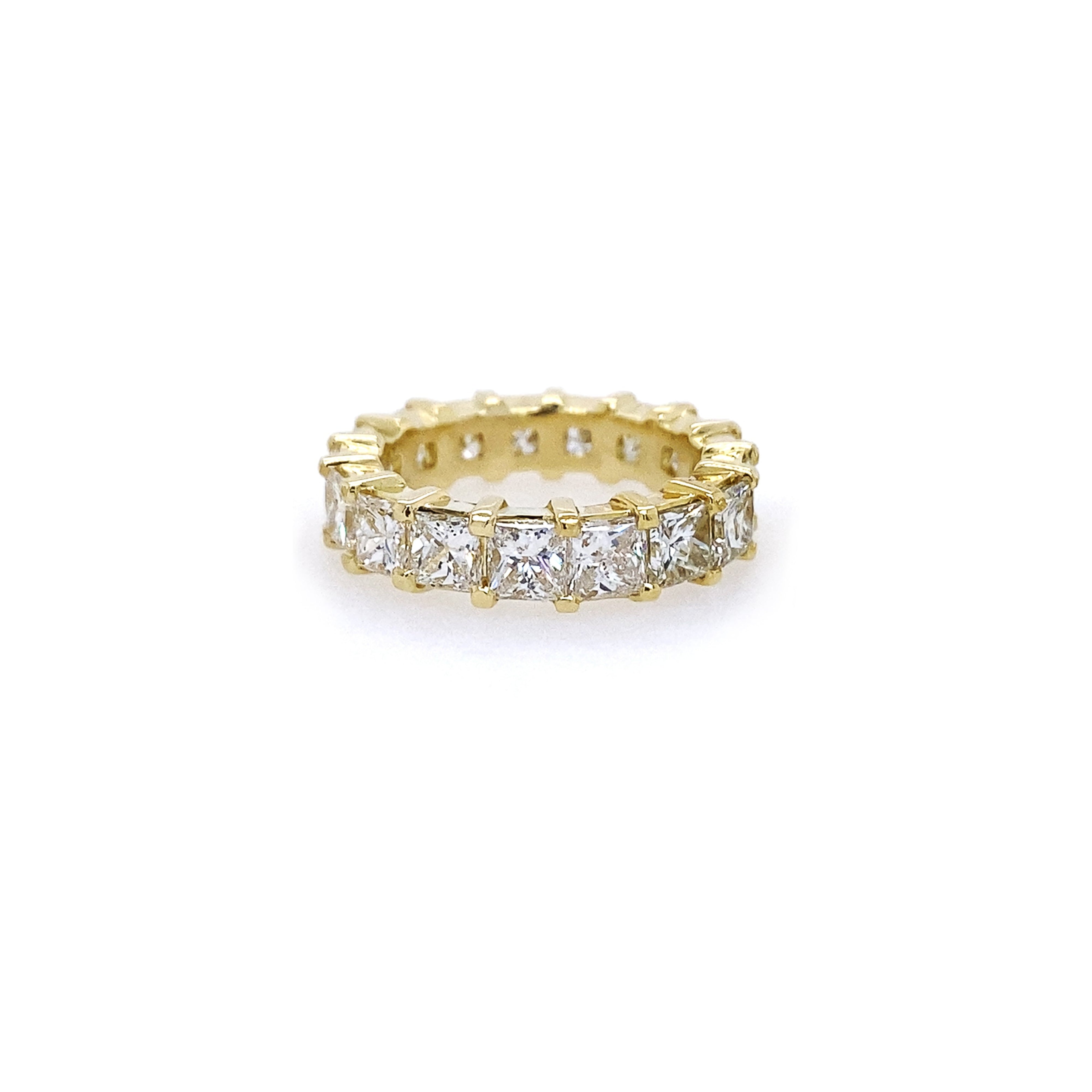 An 18K yellow gold eternity band ring with princess cut diamonds