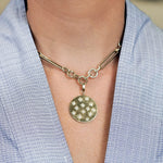 Gold necklace with a round pendant featuring diamond star designs 