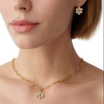 Woman wearing Temple St Clair 18K Gold Snow Flower charms covered in diamonds
