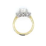 An 18K yellow gold and platinum ring featuring a rectangular clear diamond in a four-prong setting with smaller accent stones on either side, shown against a plain white background.