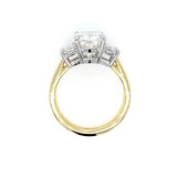 An 18K yellow gold and platinum ring featuring a rectangular clear diamond in a four-prong setting with smaller accent stones on either side, shown against a plain white background.
