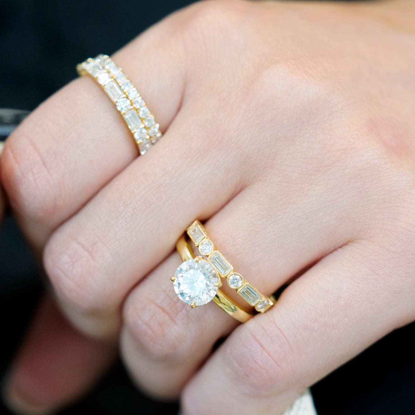 woman wearing multiple 18K yellow gold diamond rings