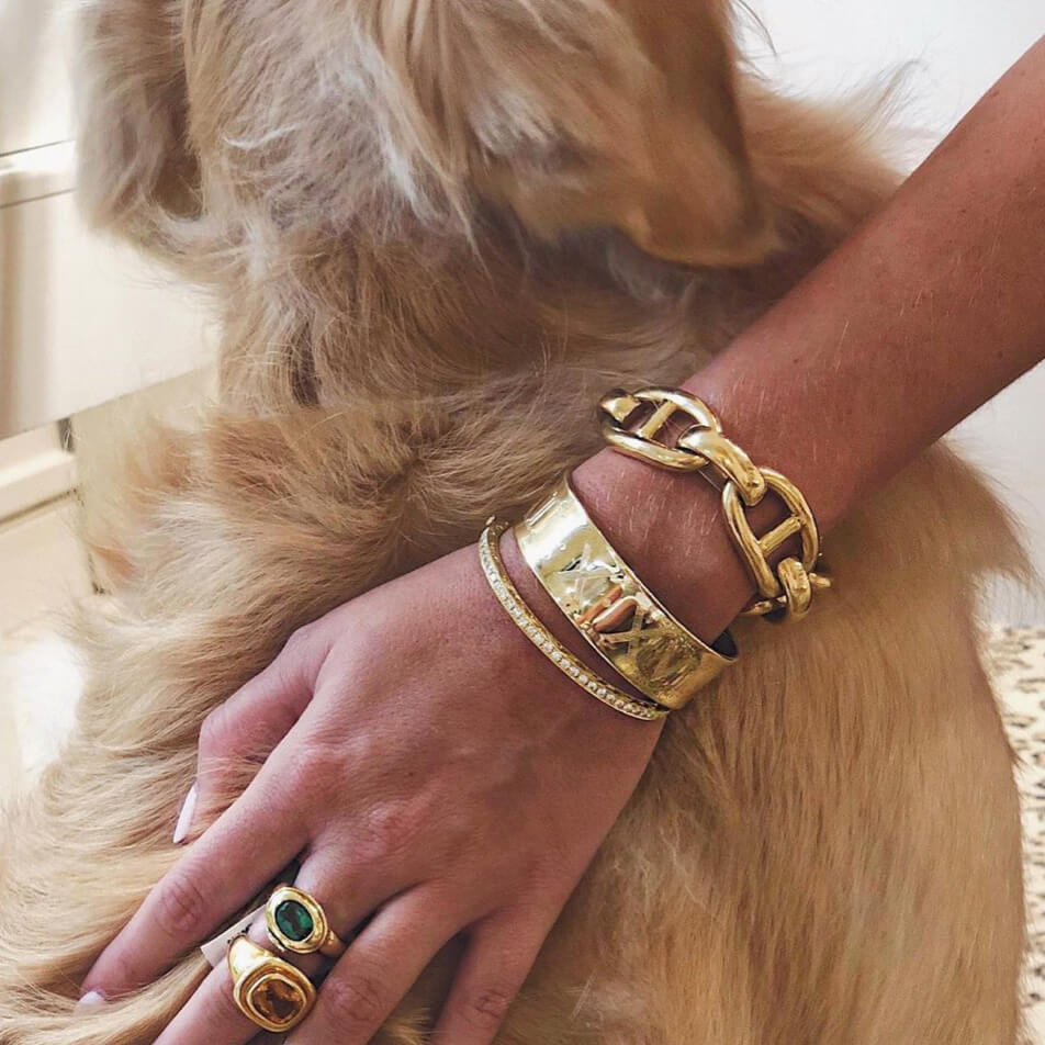 woman wearing several gold bracelets and rings