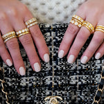 woman wearing multiple 18K yellow gold diamond band rings