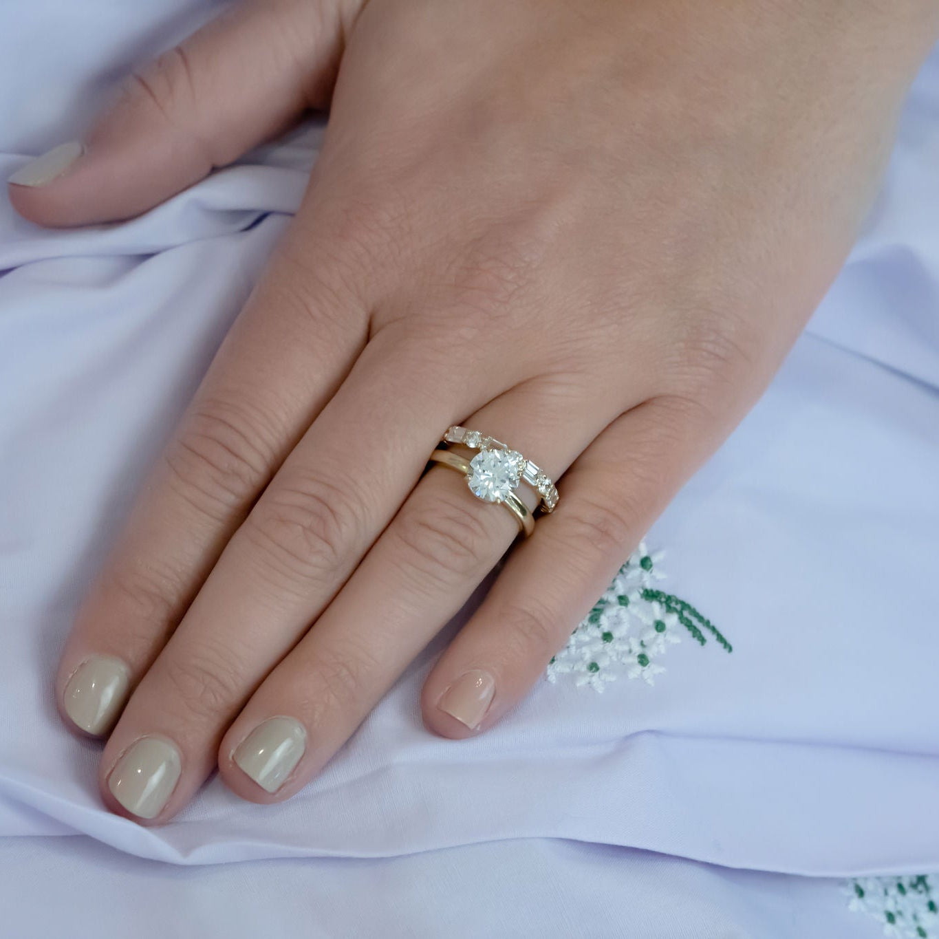 woman wearing round brilliant cut diamond ring designed by Laura Pearce