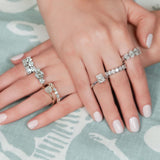 woman wearing several diamond engagement rings