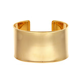 A wide cuff bracelet made of 14K yellow gold, with a smooth, polished finish.