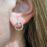 woman wearing 14k gold flat gold circle earrings with diamonds