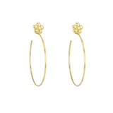 A pair of 18k yellow gold hoop earrings with a floral design at the top, against a white background.