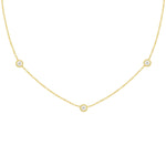 An 18k yellow gold necklace with a twist bezel diamond design featuring three diamonds by the yard.