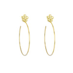 A pair of 18k yellow gold hoop earrings with a floral design at the top, against a white background.