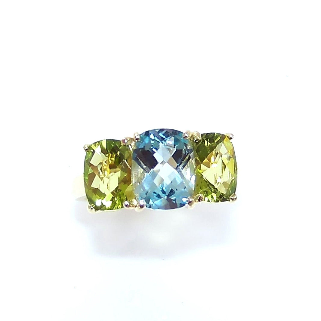 A custom designed ring with blue topaz and peridot stones set in an 18K gold band.