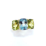 A custom designed ring with blue topaz and peridot stones set in an 18K gold band.