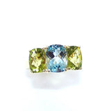 A custom designed ring with blue topaz and peridot stones set in an 18K gold band.