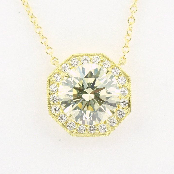 An 18K yellow gold pendant featuring a central diamond, surrounded by smaller clear diamonds set in a geometric pattern.