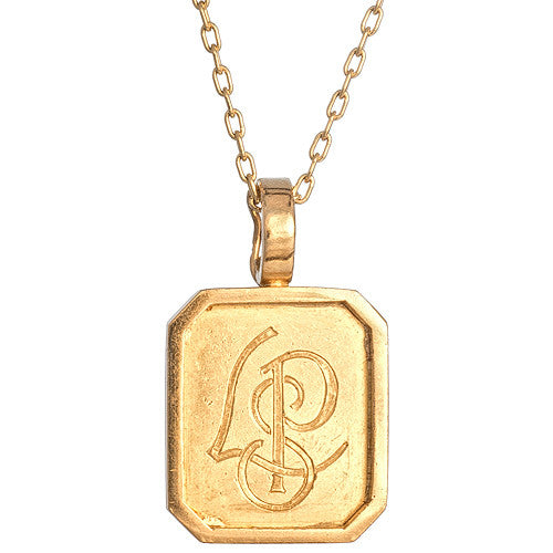 An 18kt yellow gold rectangular pendant with a vintage design engraved with initials