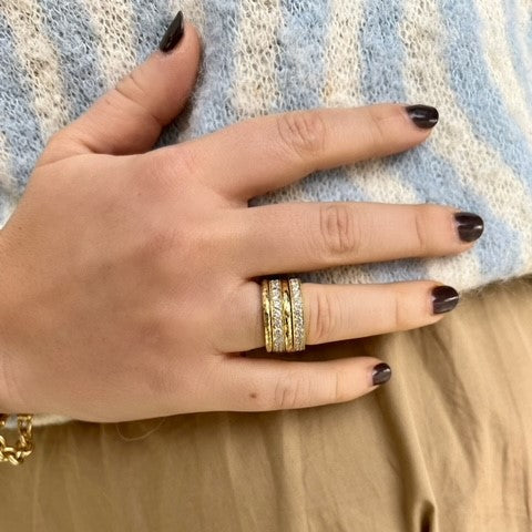 woman wearing 18K gold bead set diamond band ring