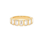 An 18K yellow gold band ring with bezel set baguette cut diamonds