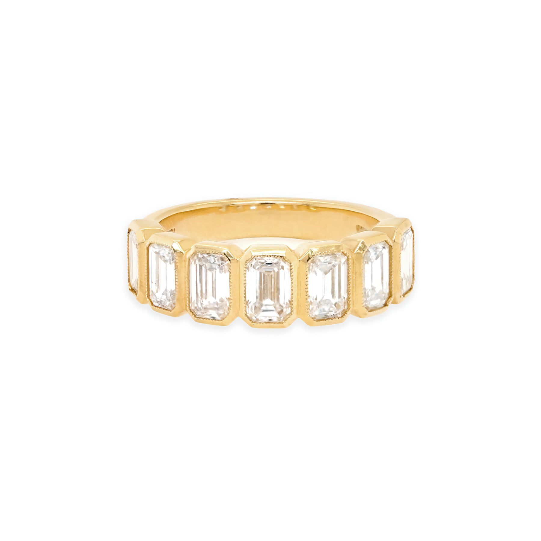 An 18K yellow gold band ring with bezel set baguette cut diamonds