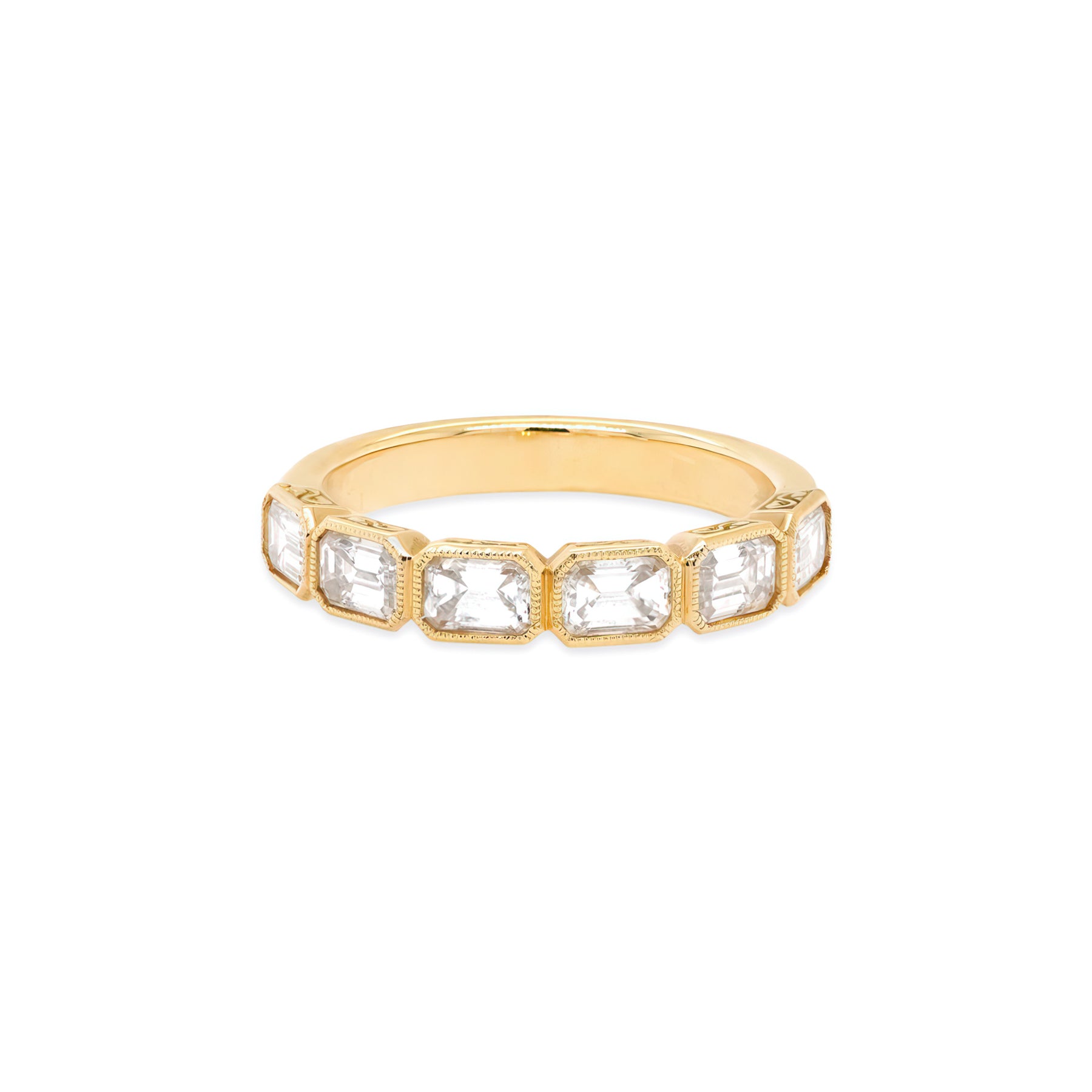 An 18K yellow gold band ring with emerald cut diamonds oriented east-west.