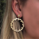 Woman wearing 18k yellow gold diamond drop earrings