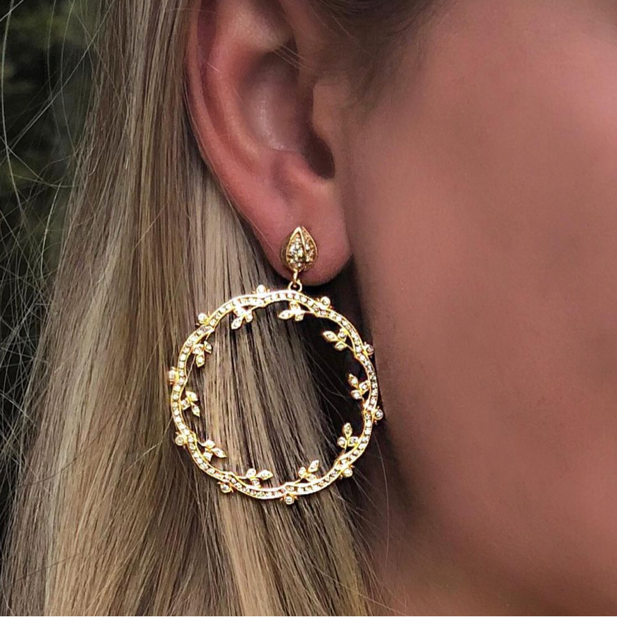 Woman wearing 18k yellow gold diamond drop earrings