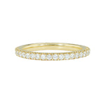 An 18K yellow gold eternity band with shared prong set diamonds