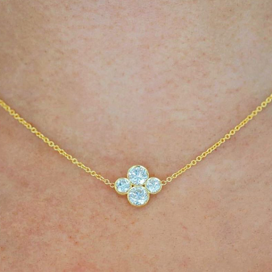 Close-up on-model shot of18k yellow gold necklace with an Anderson diamond design featuring four diamonds in a cluster