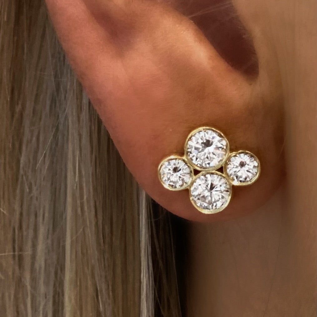 close-up of an 18K Gold earring with diamonds on a woman's ear