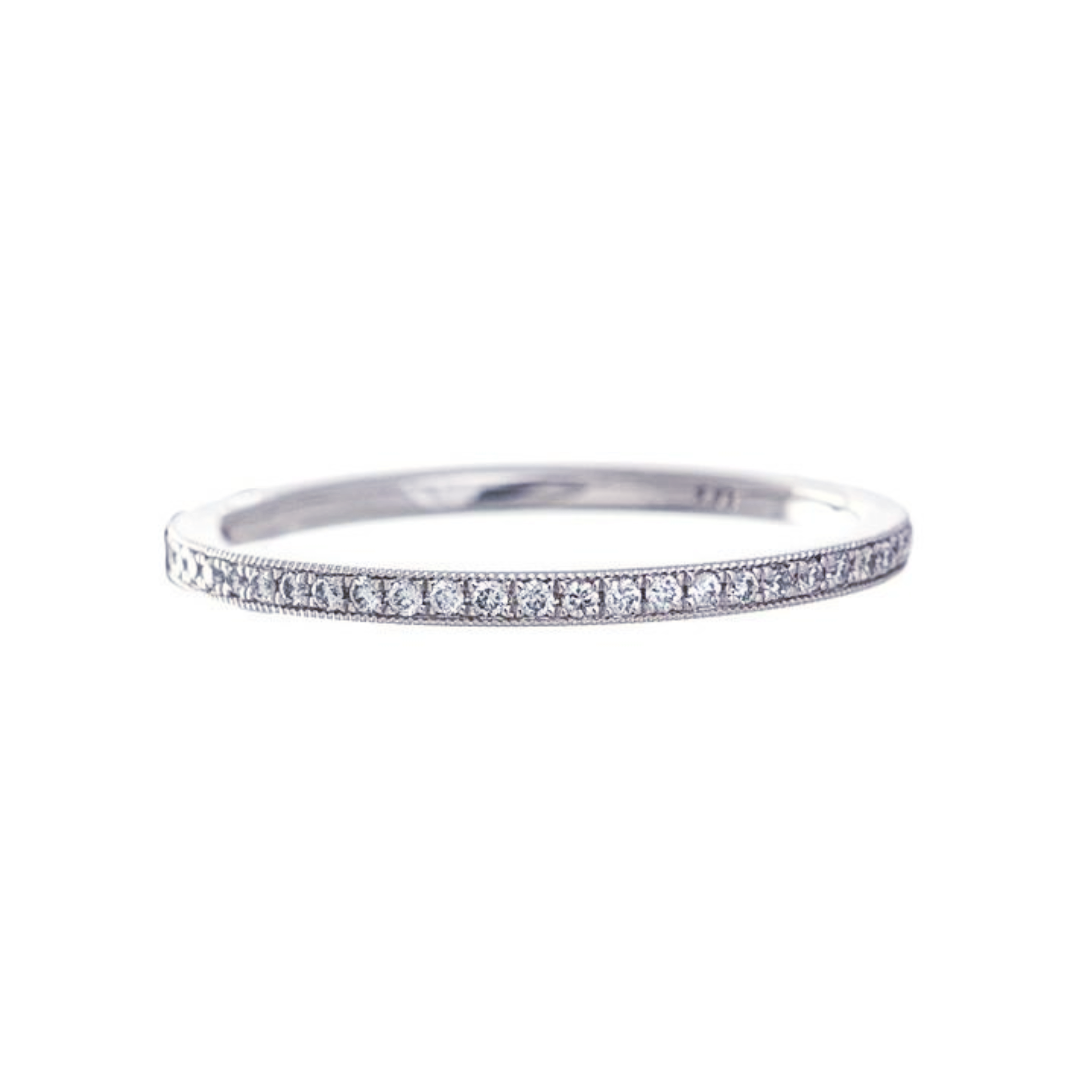 A platinum eternity band with bead set diamonds and milgrain