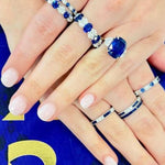 woman wearing several sapphire and diamond rings designed by Laura Pearce