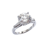 A platinum round brilliant cut diamond with tapered baguettes on the side