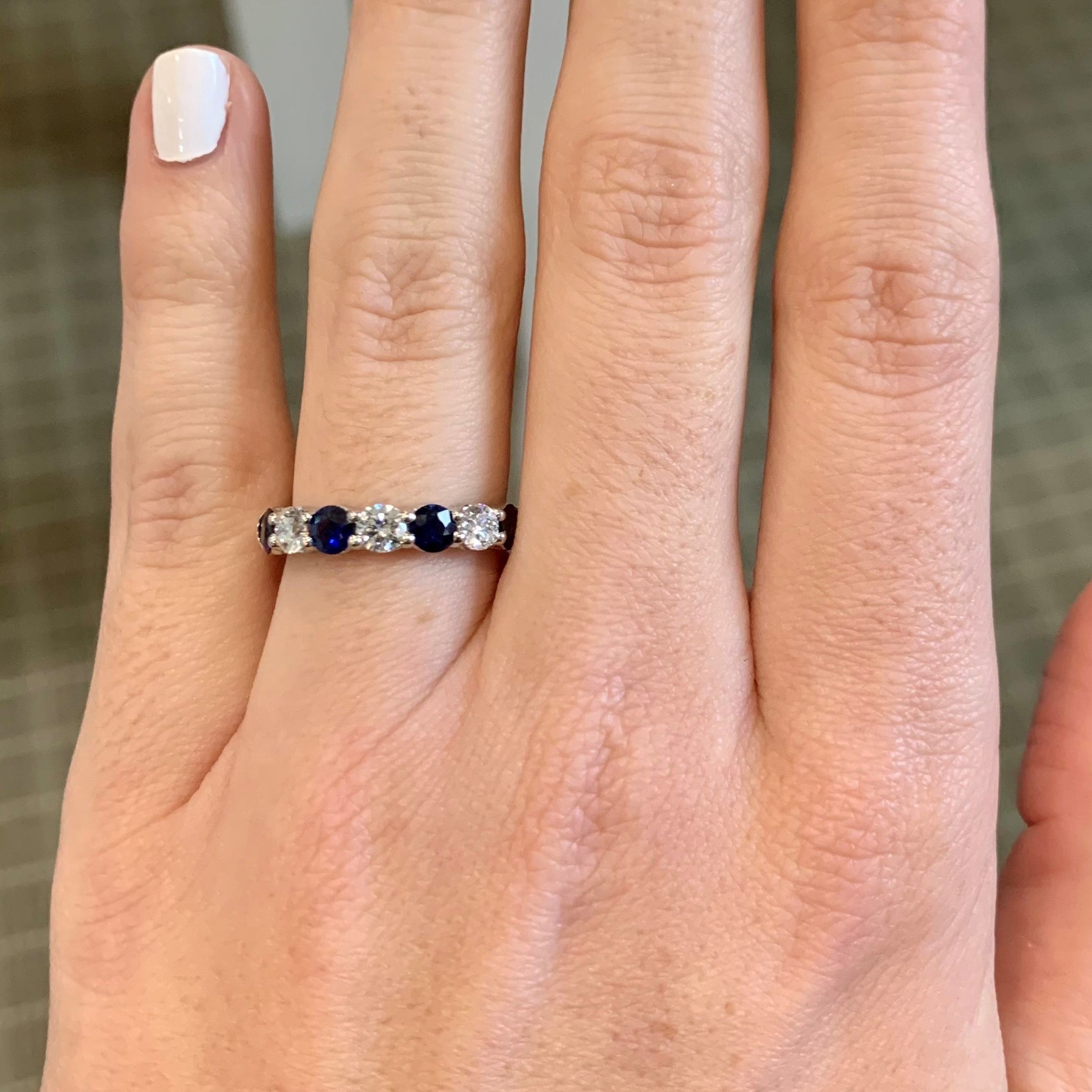 Woman wearing JB Star Platinum Round diamond and sapphire ring