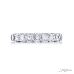 A platinum band ring with multiple diamonds set around its circumference.