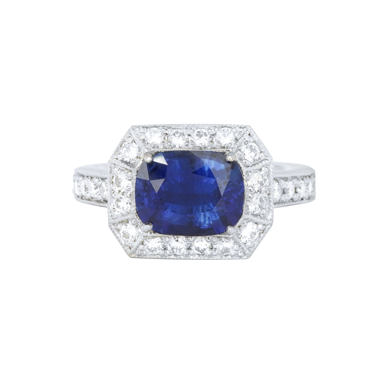 A platinum ring featuring a large blue sapphire center stone, flanked by smaller diamonds