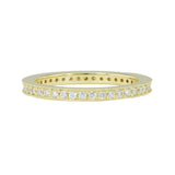 A band ring in 18K yellow gold metal embedded with multiple small diamonds around its entire circumference.