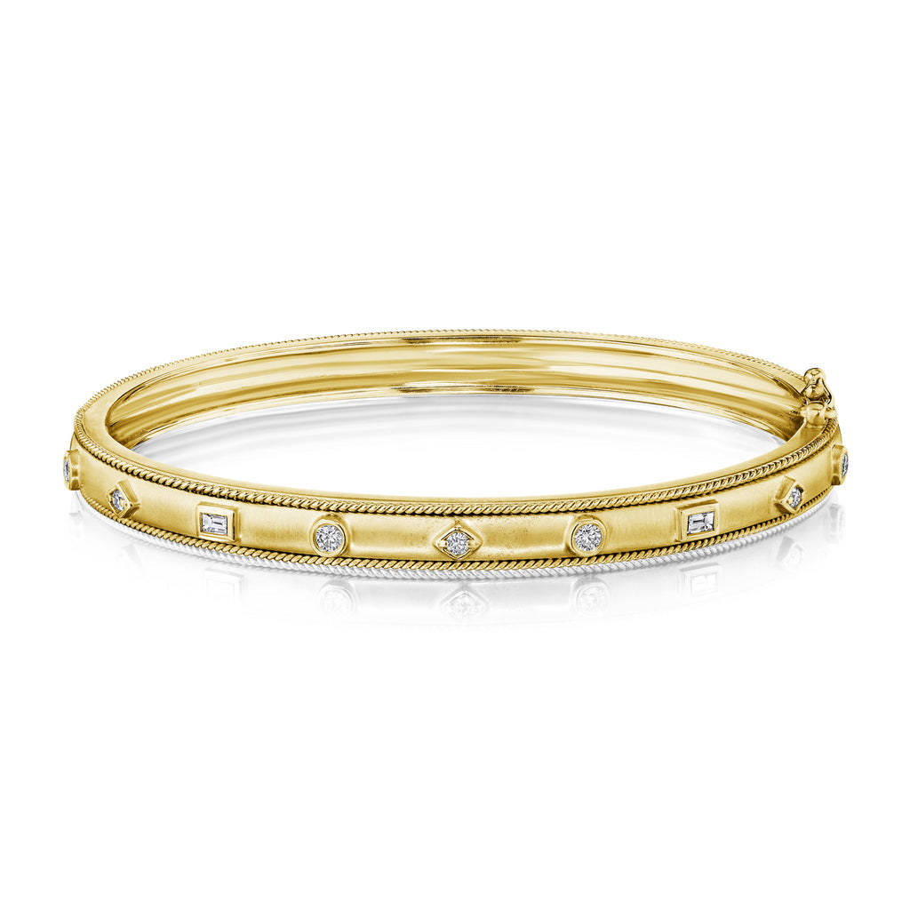 An 18K gold bangle bracelet with diamond accents, featuring mixed shape designs and a clasp closure.