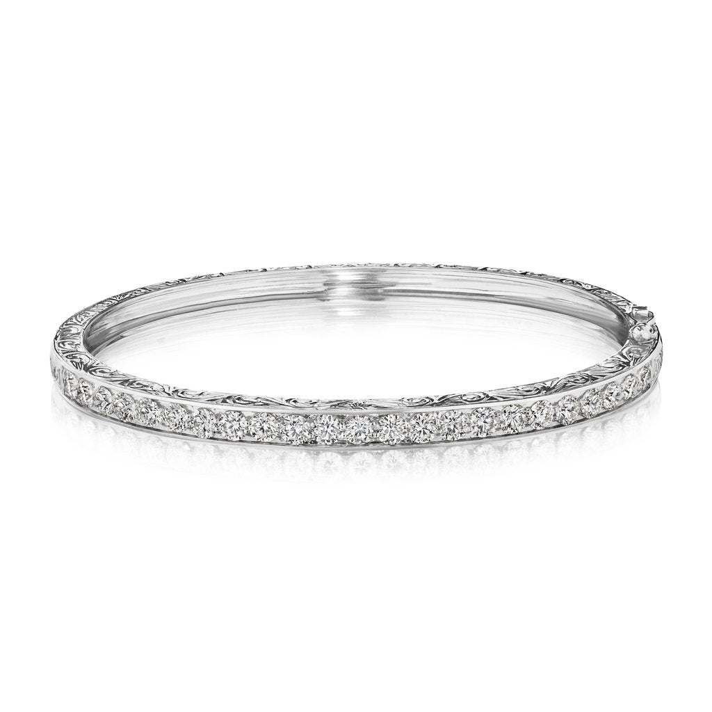An 18K white gold engraved diamond bangle bracelet 